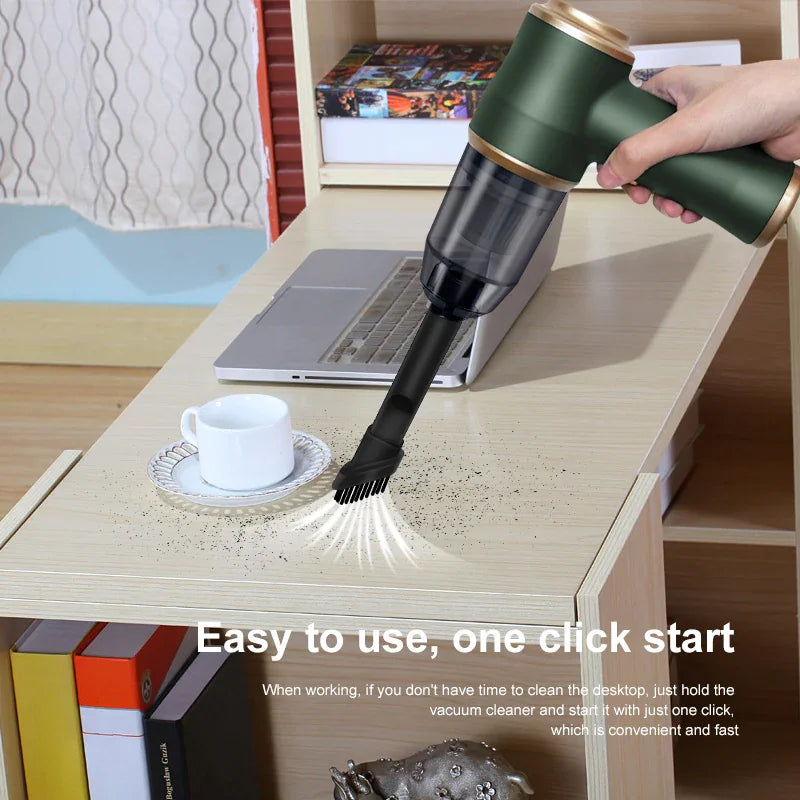 Green handheld vacuum cleaner being used to clean a desk with a laptop and a coffee cup.