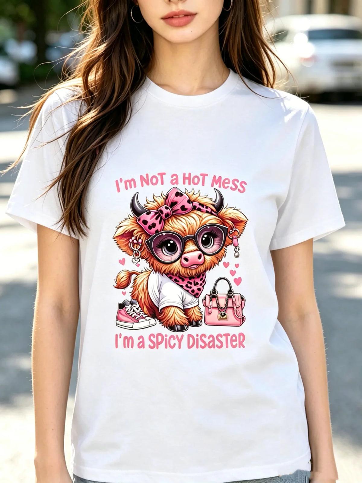 Woman wearing a white t-shirt with a Highland cow graphic print