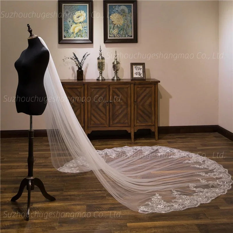 Long ivory cathedral wedding veil with lace floral appliques and bead embellishments on a mannequin, side profile