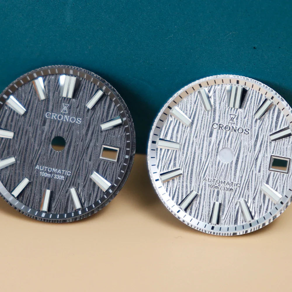 Two round wristwatch dials, one dark grey and one white, featuring birch-patterned textures and silver hour markers.