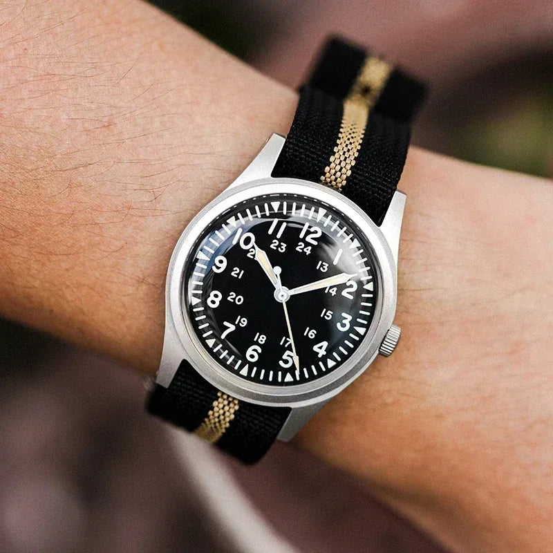 Men's military style field watch with black dial worn on a wrist