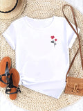 White short-sleeved t-shirt with a small red rose print, styled with a straw hat, sandals, and a small woven bag