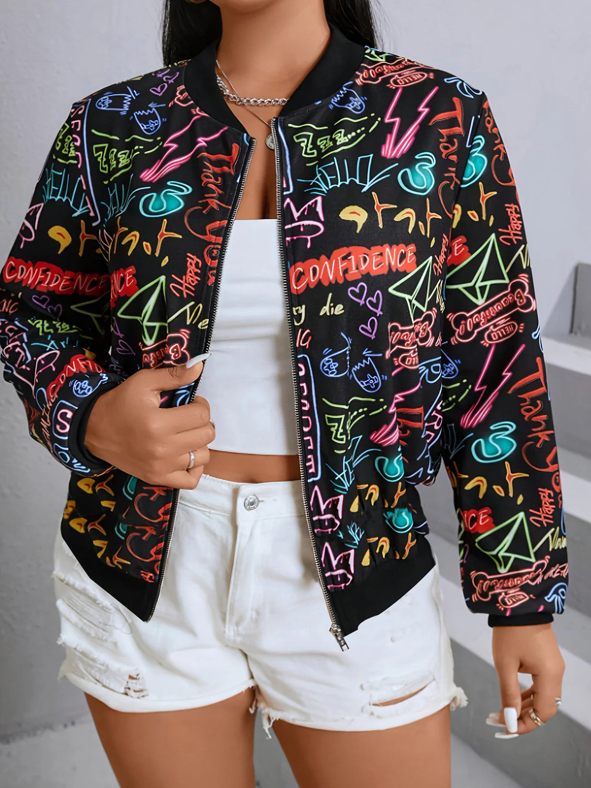 Close-up of a black bomber jacket with colorful neon-style graffiti print.