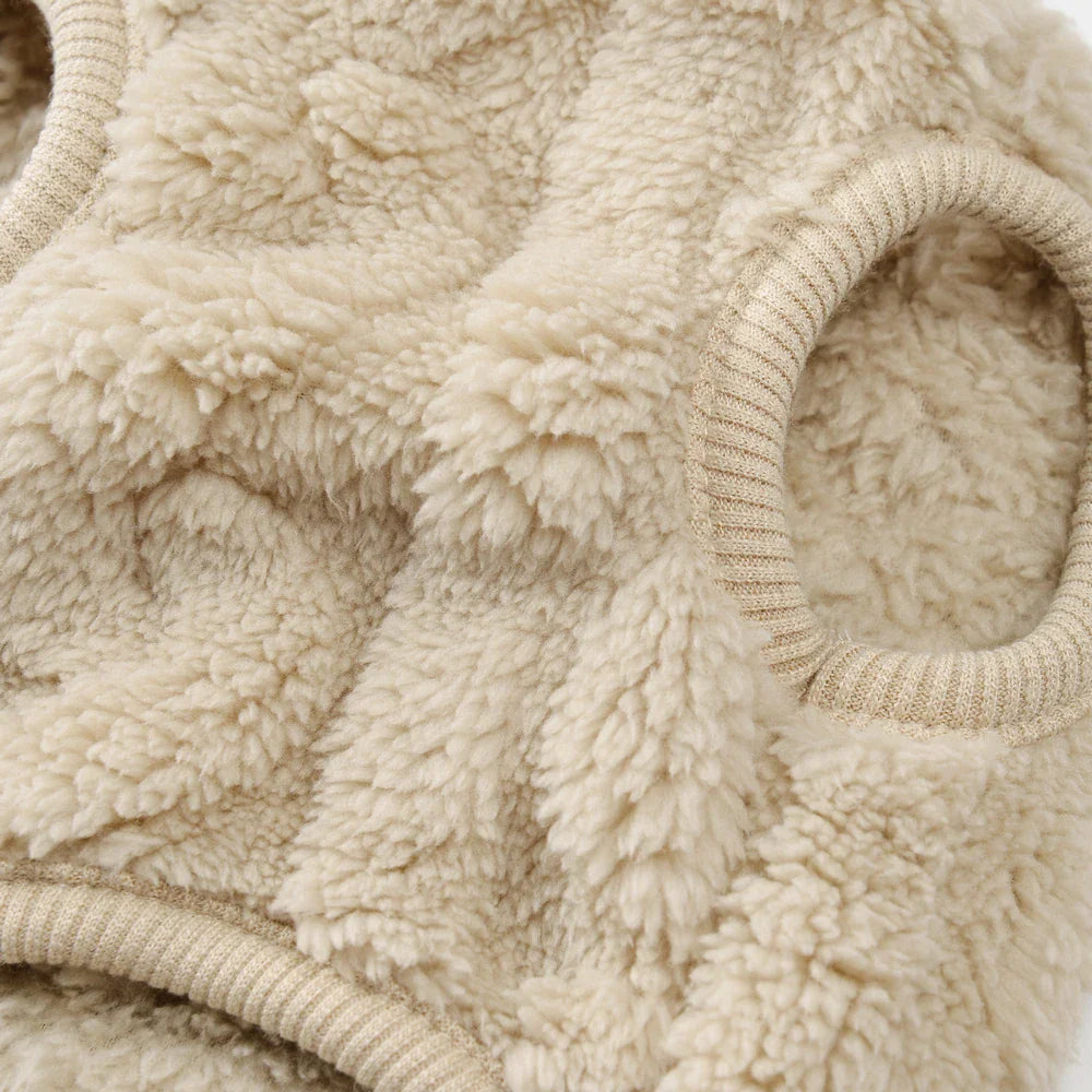 Close-up of a beige textured fleece dog sweater sleeve opening.