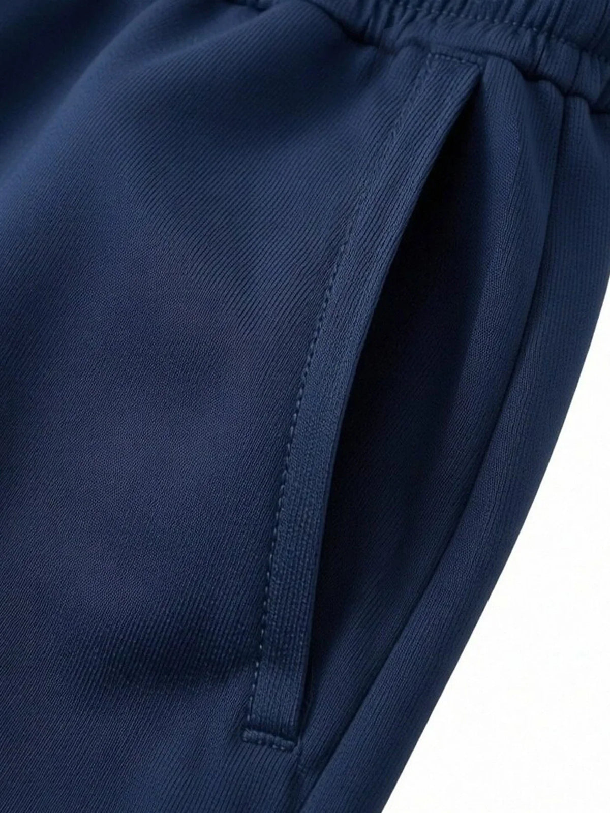 Close-up of the pocket on navy blue sports shorts.
