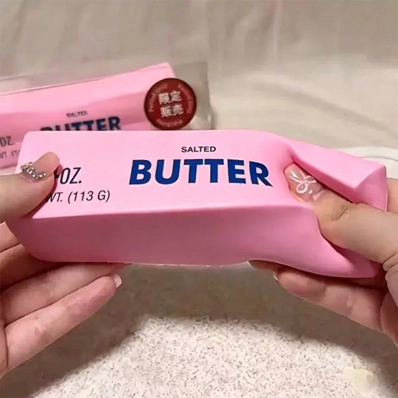 Pink butter stick shaped squishy toy being squeezed