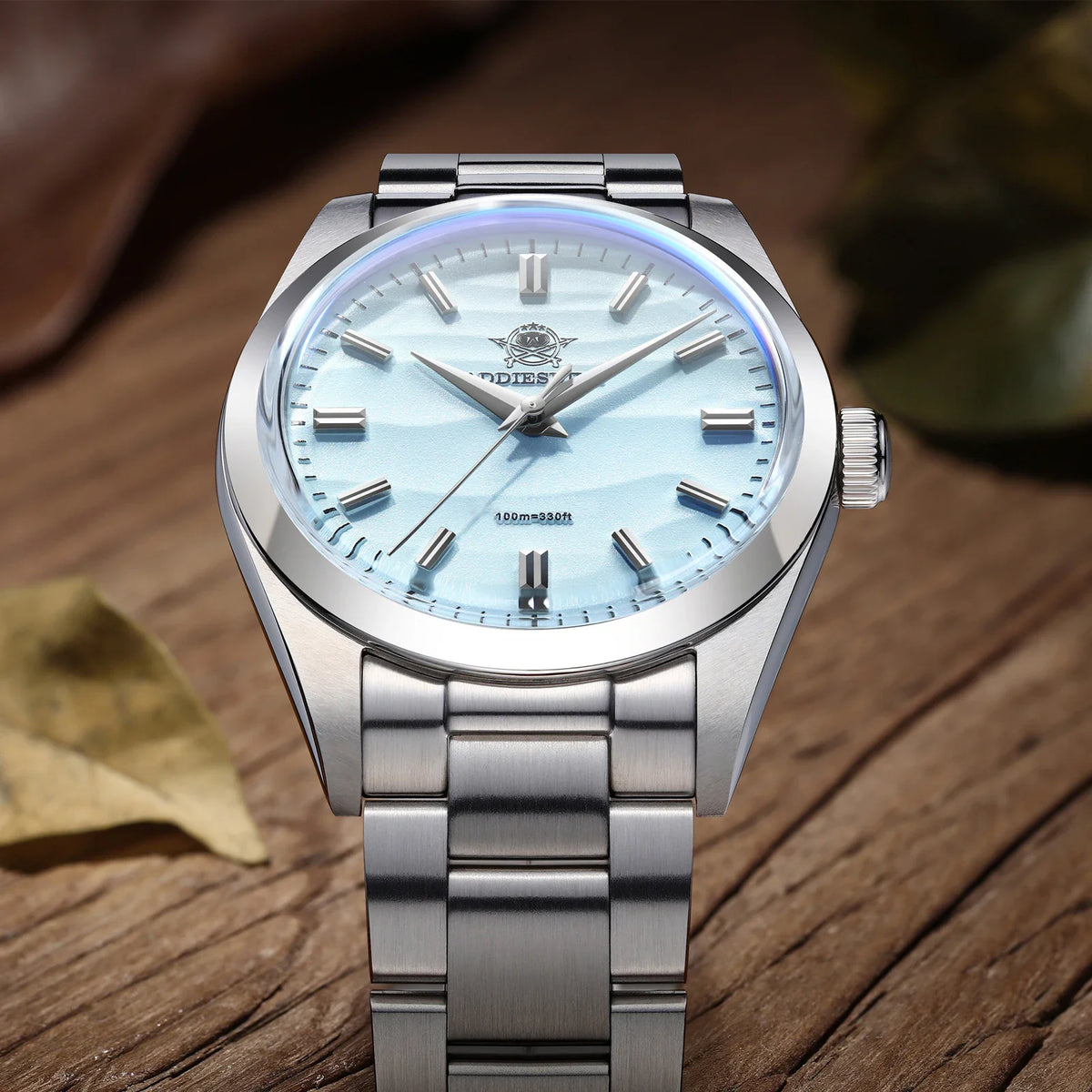 Close-up of a stainless steel wristwatch with a light blue textured dial and bubble crystal
