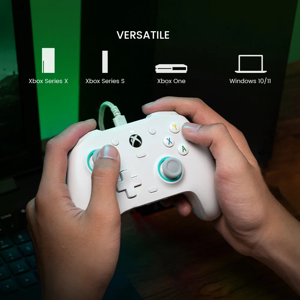 Hands holding a white wired gaming controller with console compatibility icons