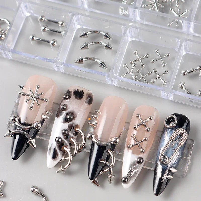 Storage organizer filled with assorted silver metal nail art studs next to decorated long manicured nails
