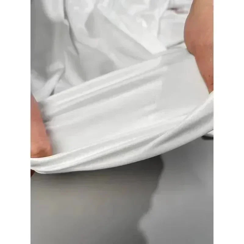 Close up hands stretching the fabric of a white tank top to demonstrate elasticity.
