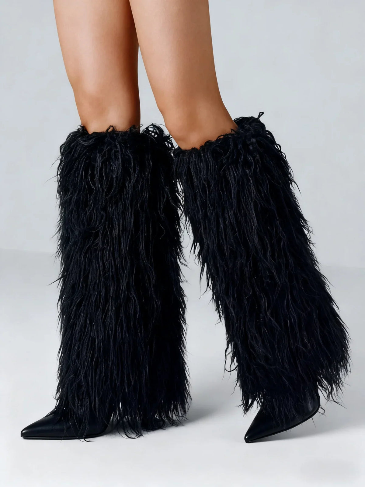 Black faux fur knee high stiletto boots with a pointed toe