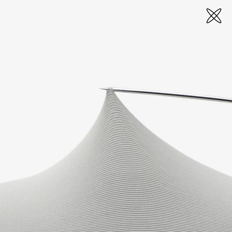 Close up of stretchy light grey fabric being pulled by a needle