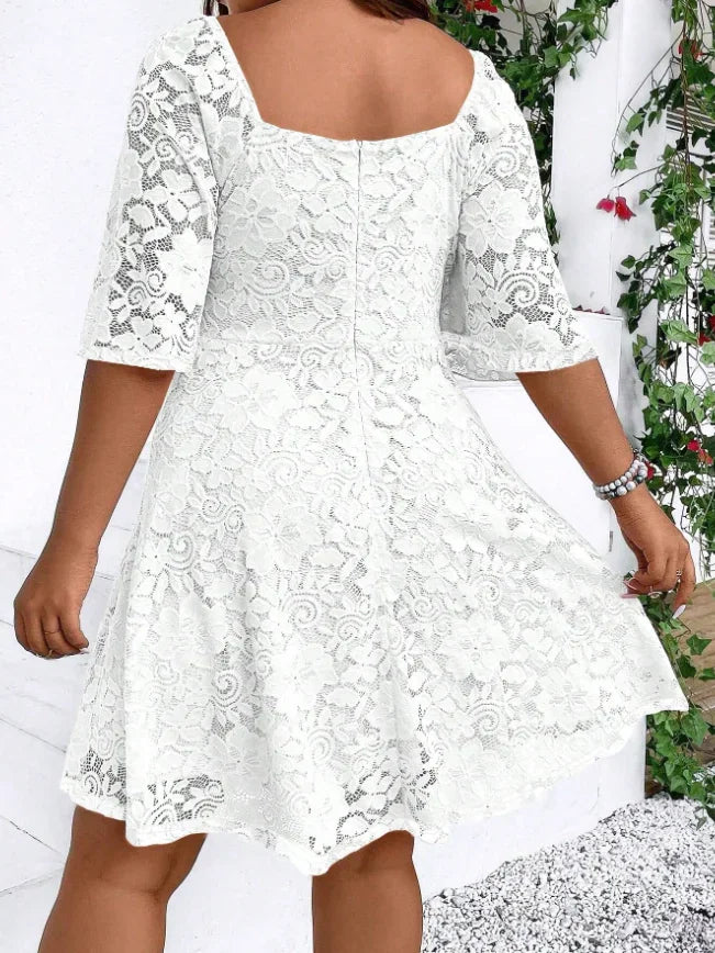 Back view of a white lace mini dress with short flutter sleeves and a V-neckline