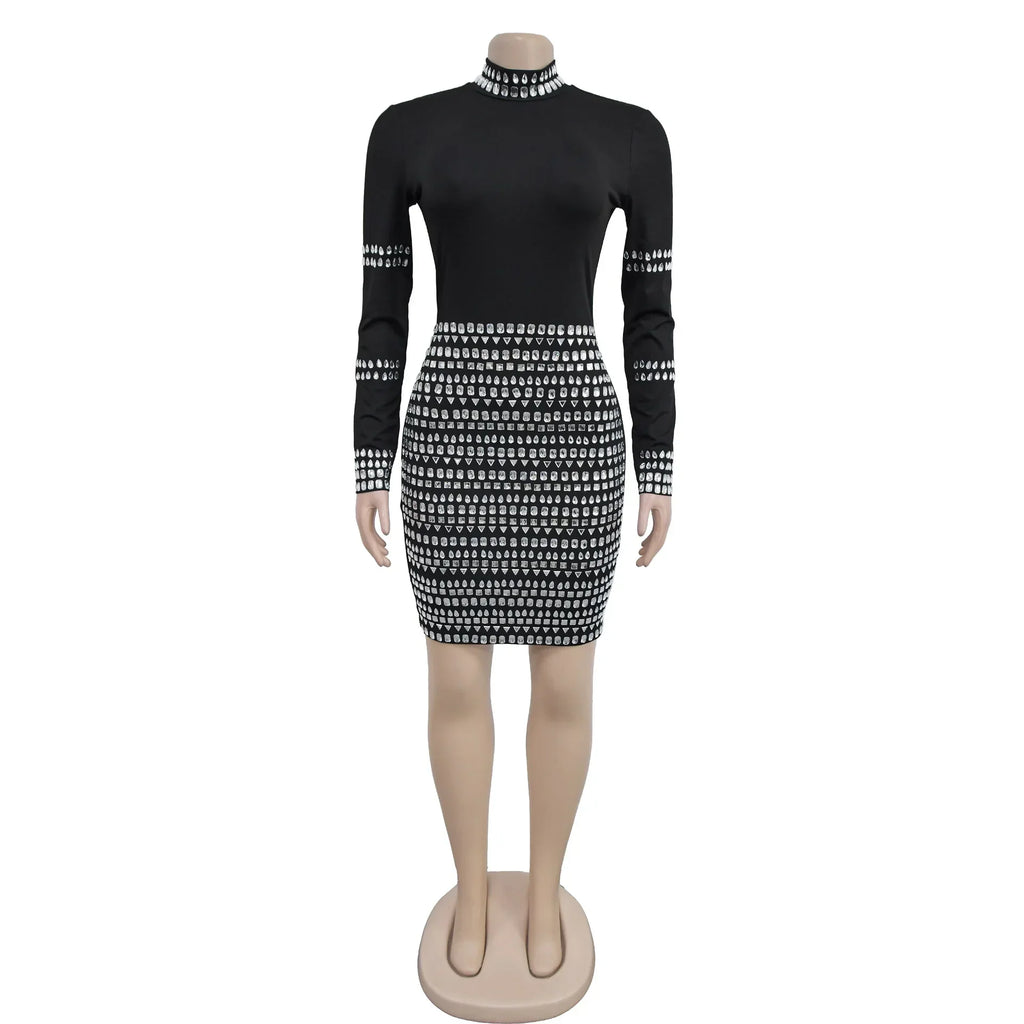 Black mini dress with long sleeves and heavy silver rhinestone embellishments on a mannequin.