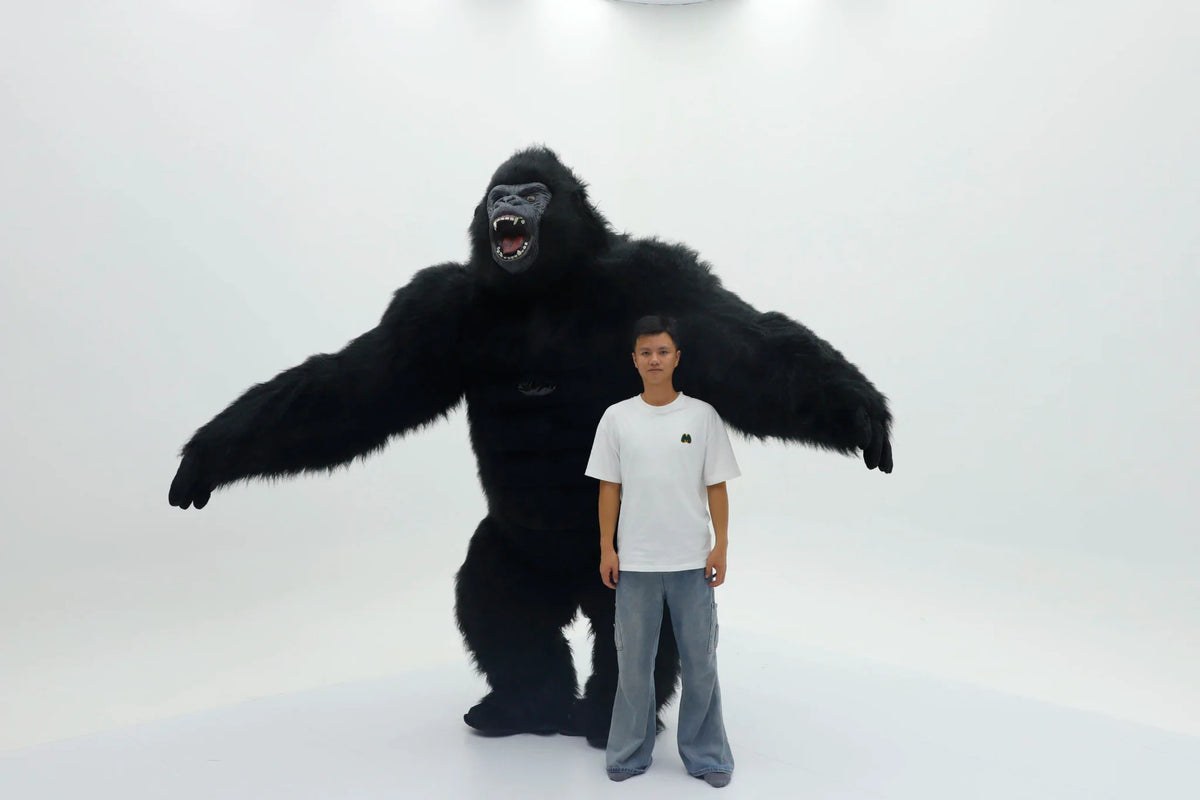 A black king kong mascot costume standing behind a man.