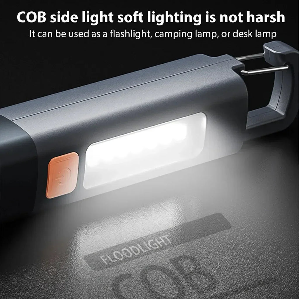 Close up of a grey handheld LED flashlight with COB side light switched on