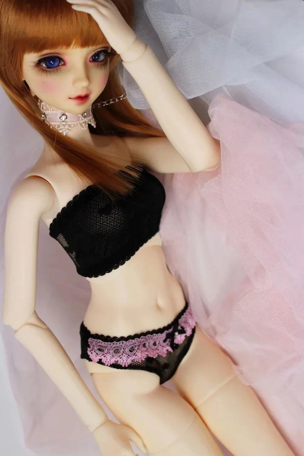 A BJD doll wearing a black lace tube top and black and pink lace briefs