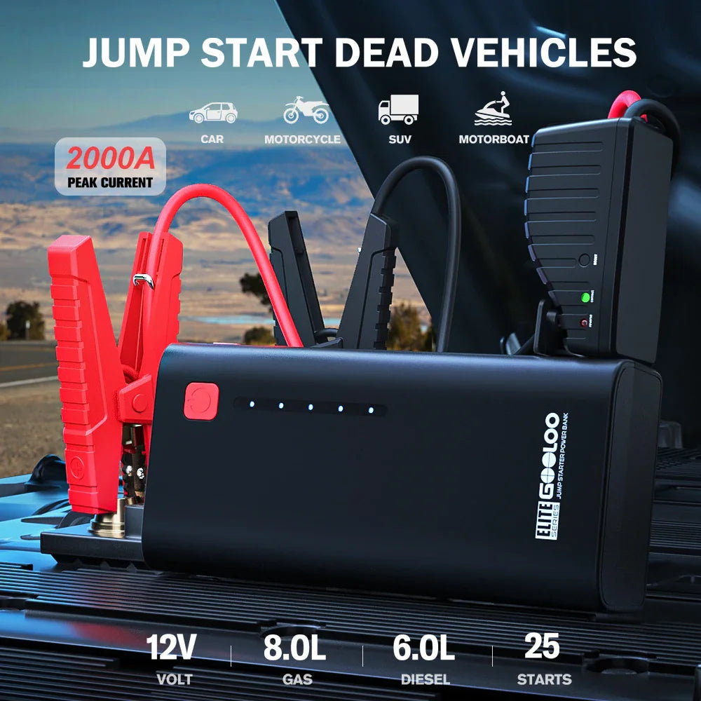 Black automotive jump starter power bank connected to car battery with jumper cables