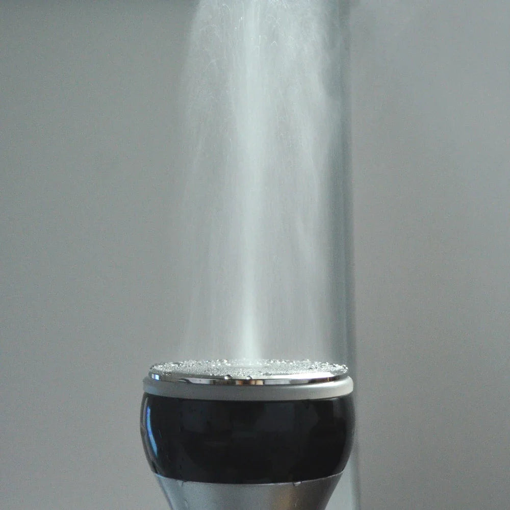 A close-up of a cavitation machine nozzle emitting a fine mist during use.