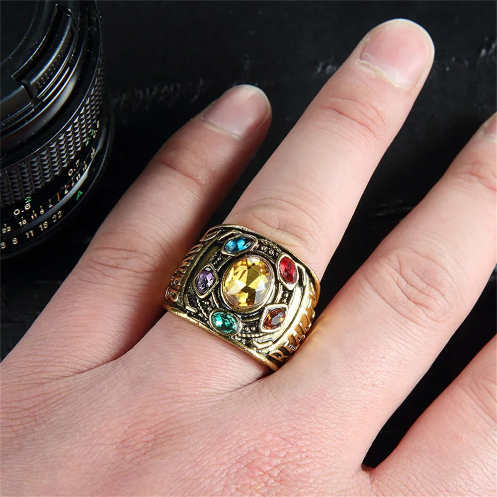 Hand wearing an antique gold tone ring with colorful crystals