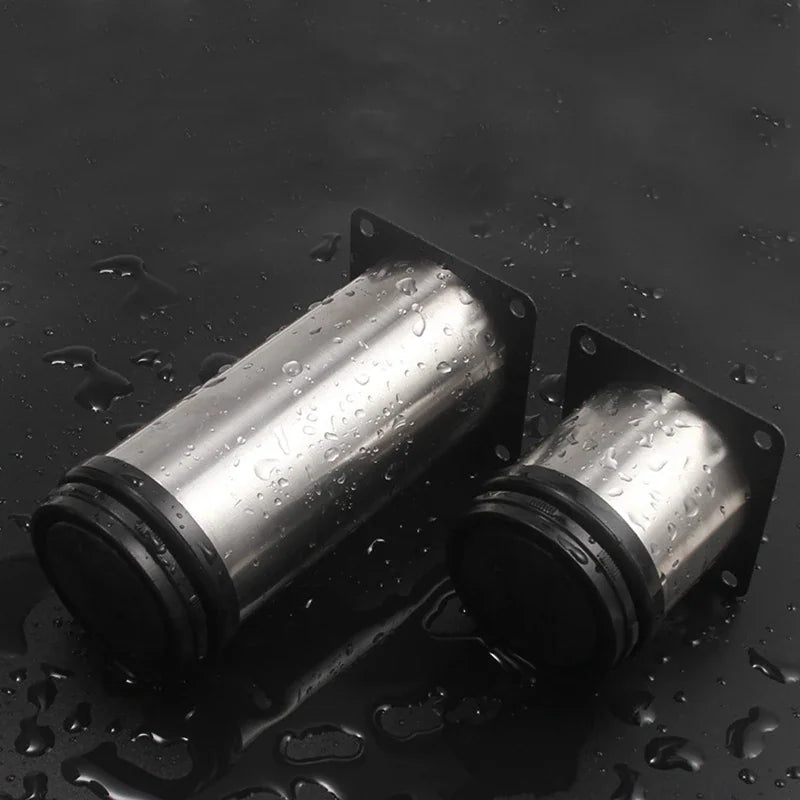 Two stainless steel furniture legs with mounting plates on a black surface with water droplets