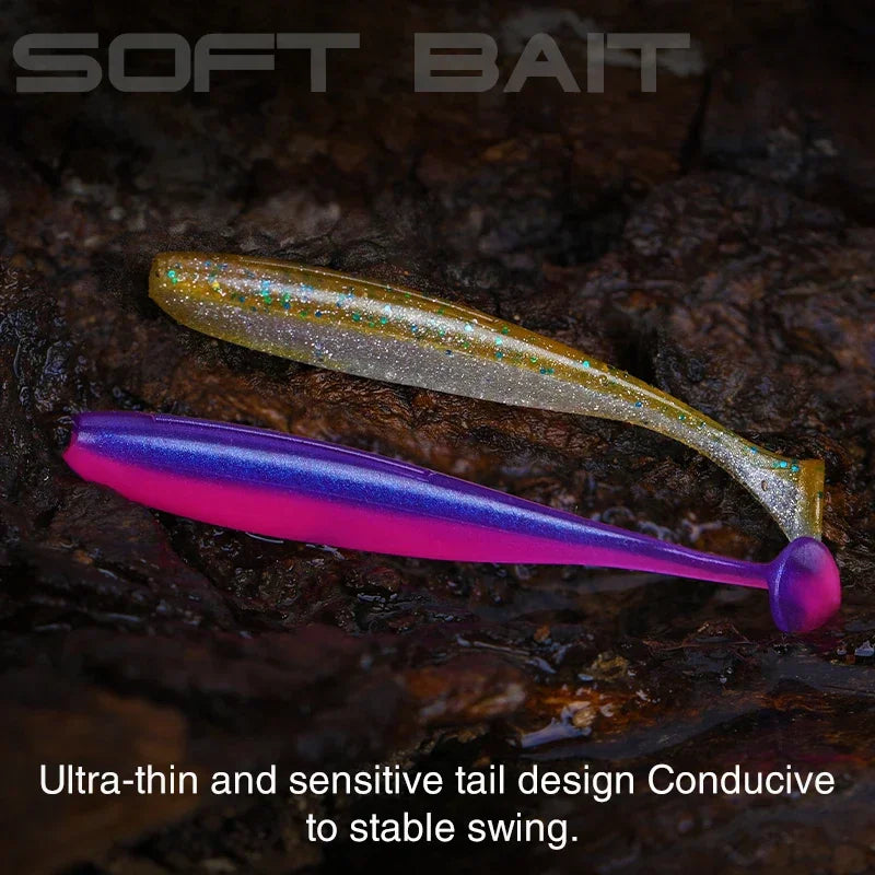 Two T-tail soft plastic lures placed on a textured dark ground