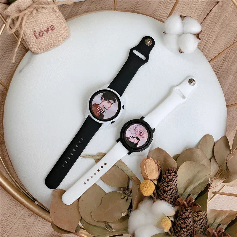 Black and white silicone watch bands laid on a decorated white surface with pinecones and cotton.