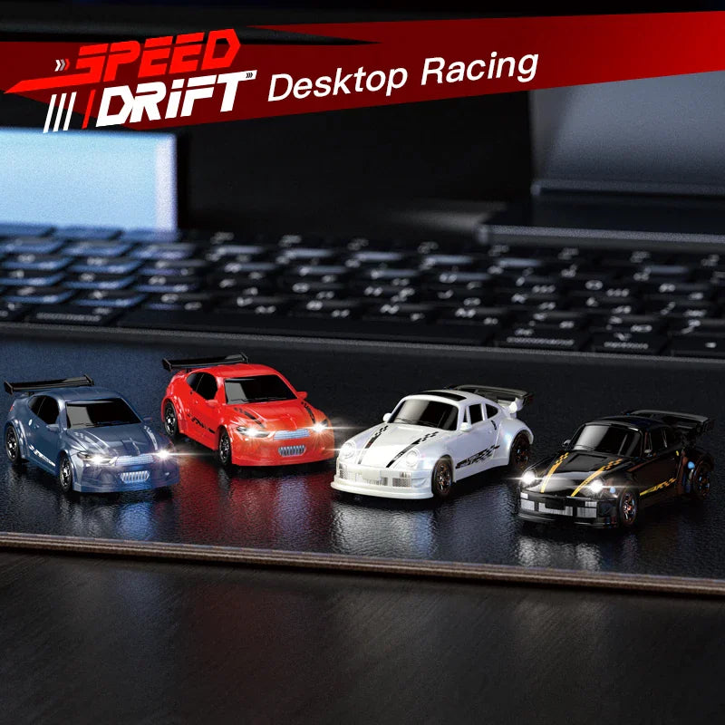 Four 1/64 scale RC drift cars in different colors parked on a desk surface