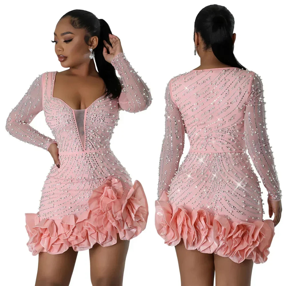 Front and back view of a pink long-sleeved mini dress with pearl and crystal embellishments and a ruffled hem.