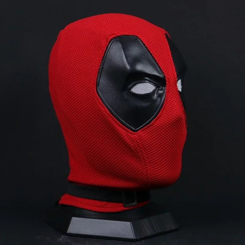 Side view of a red and black knitted superhero mask on a black display stand