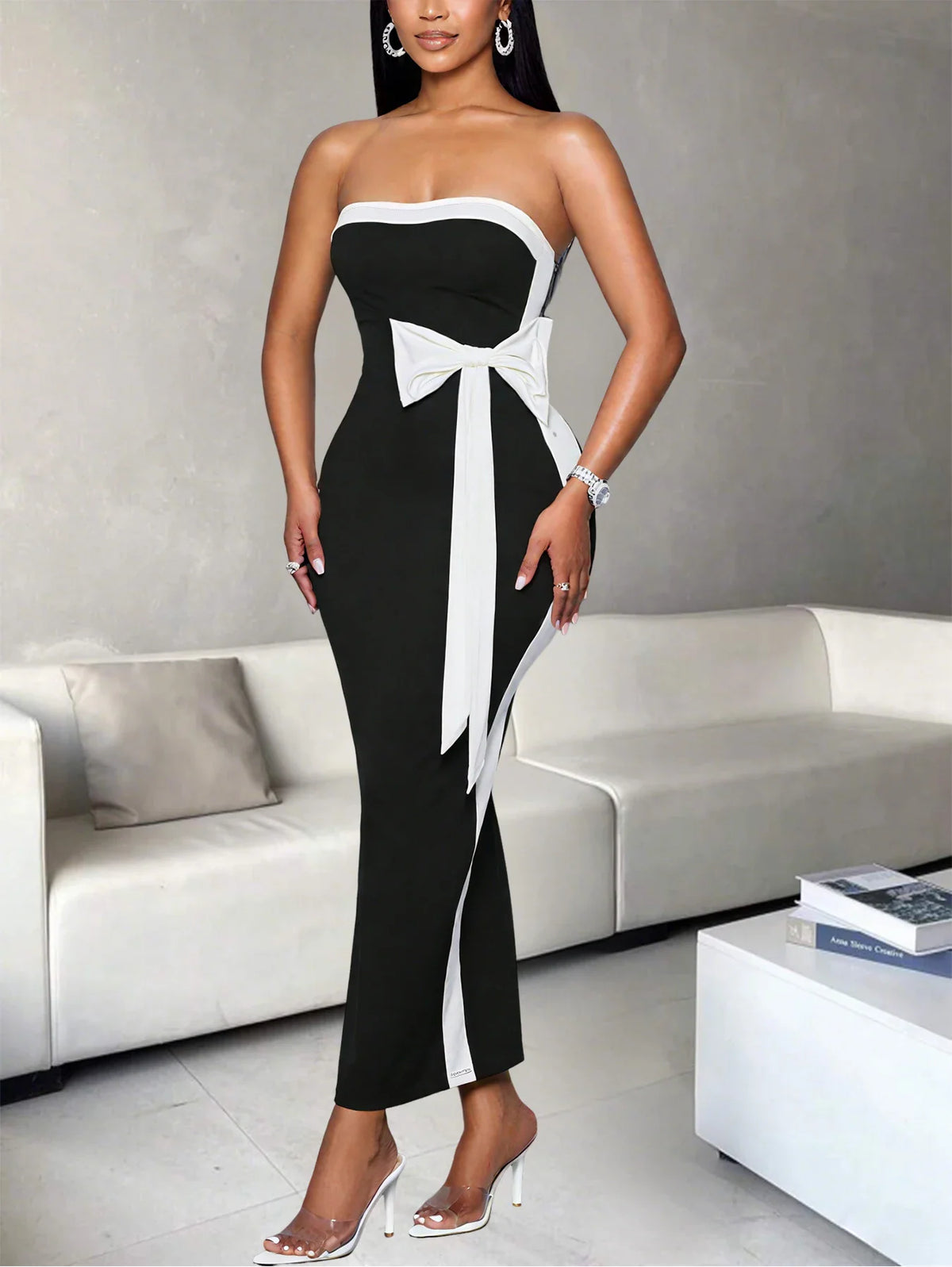 Woman in a black and white strapless midi dress with a side knot accent