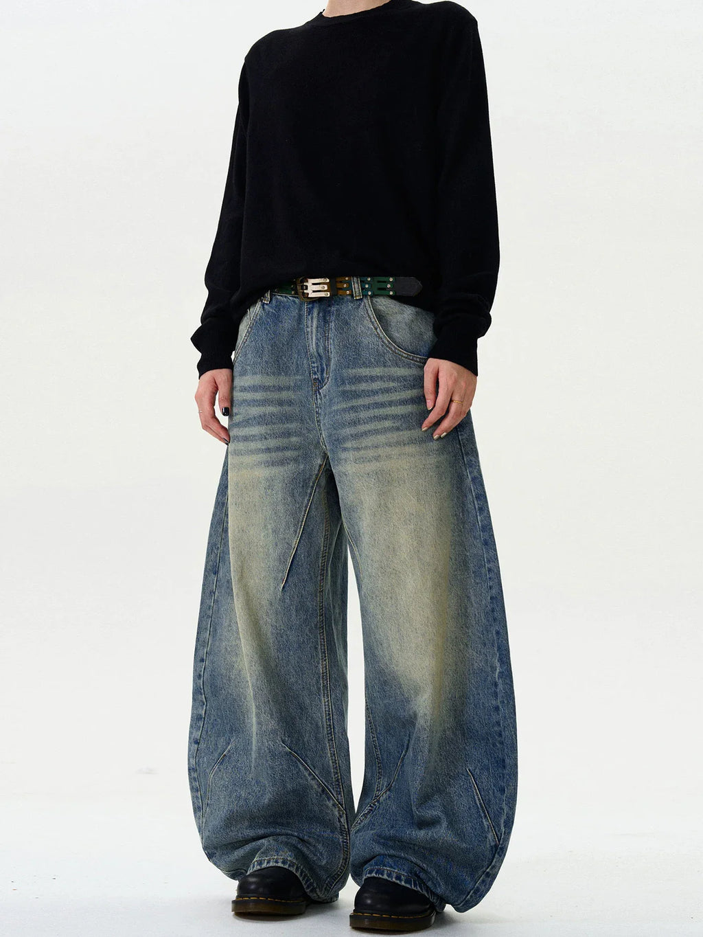 Model wearing vintage washed baggy wide leg denim jeans with black belt and black shirt