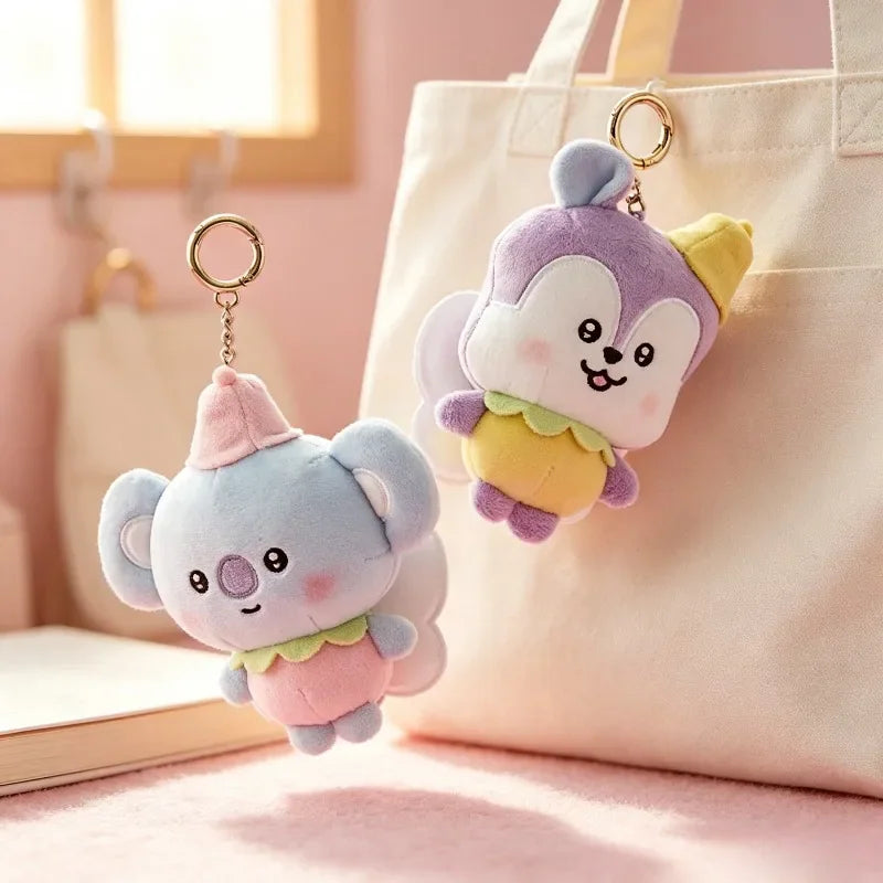 Plush koala and fox character keychains hanging from a beige canvas bag
