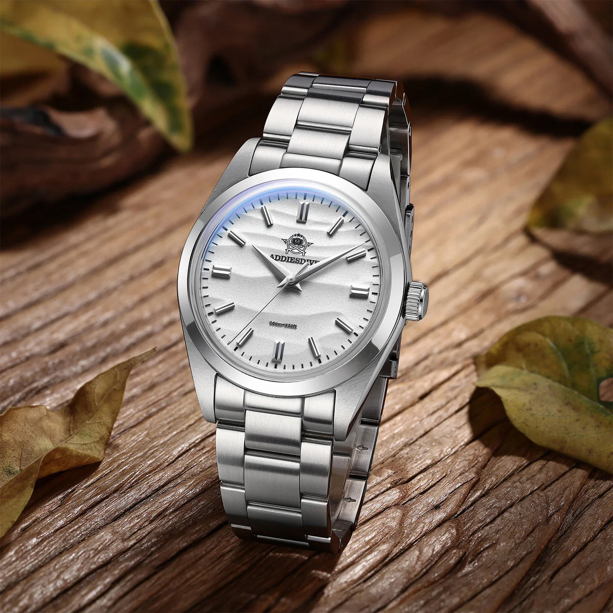 Stainless steel wristwatch with a white wave-patterned dial on a wooden background