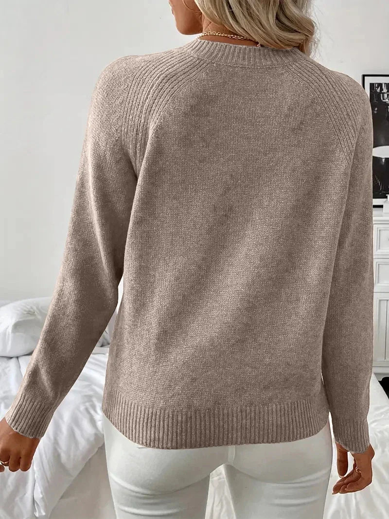 Back view of a woman wearing a long-sleeved taupe knit sweater