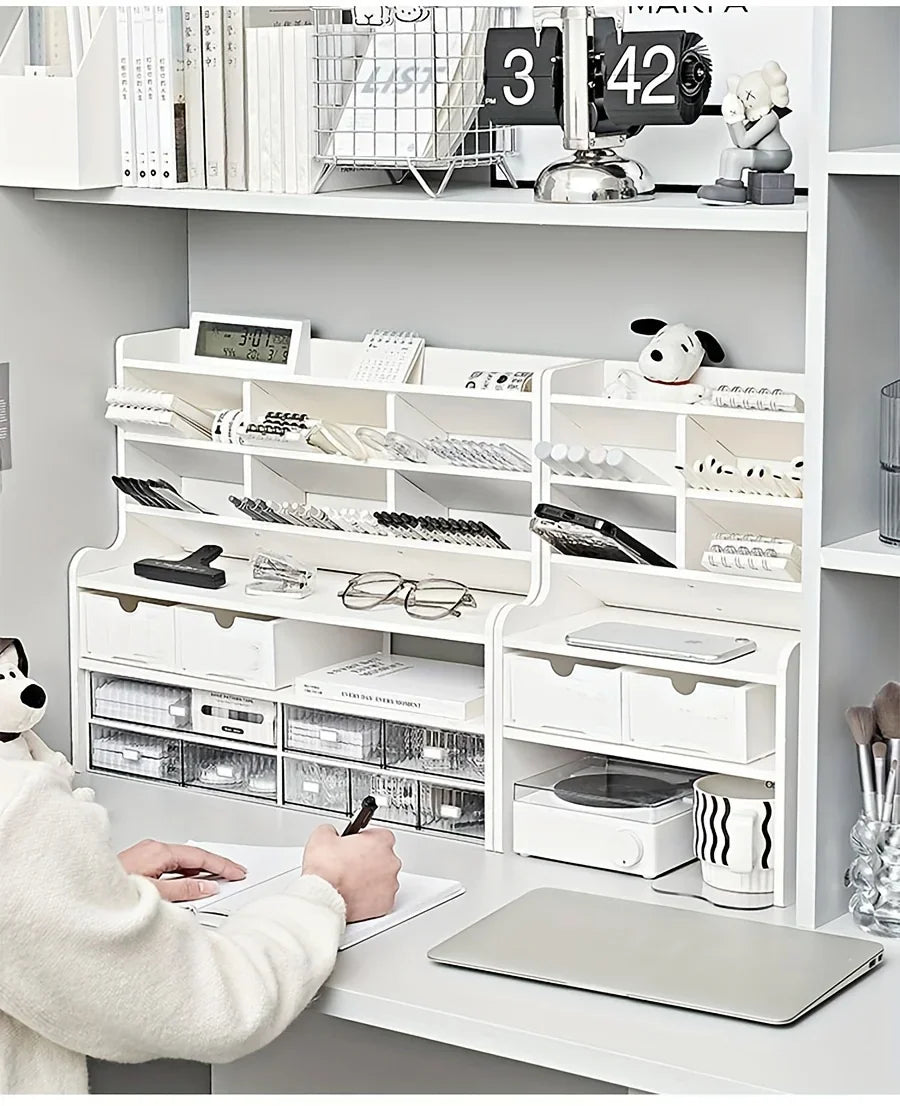 Person writing at a desk with a white multi-level organizer