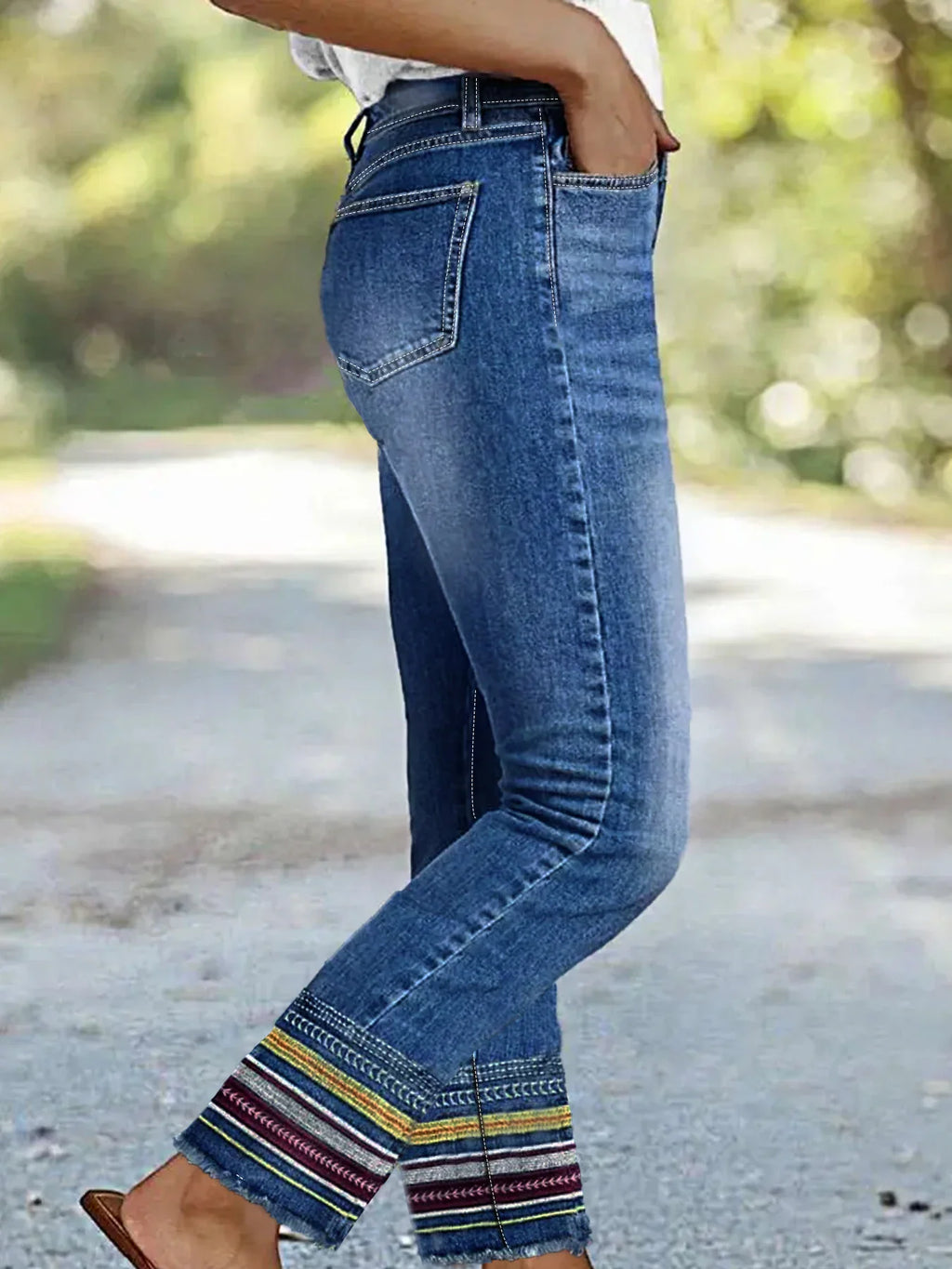 Side view of blue denim jeans with high waist and embroidered cuffs