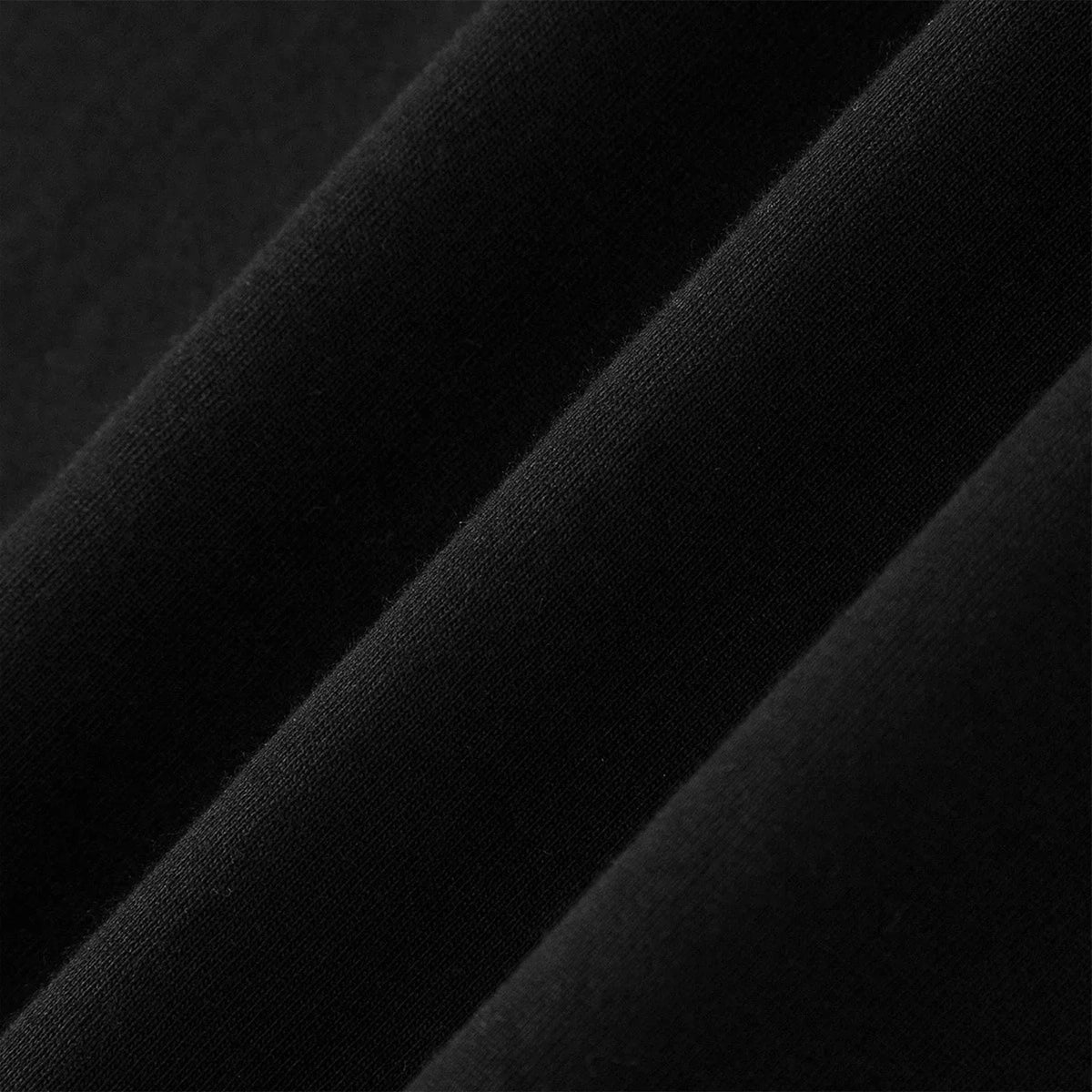 Close-up detail of the black cotton fabric texture showing weave and folds