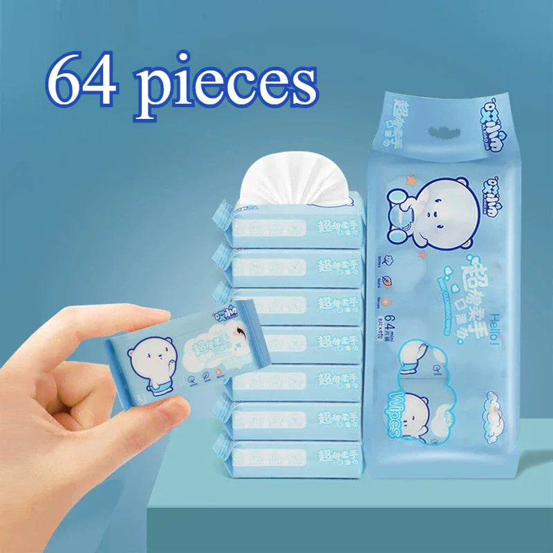 A hand holding a mini pack of baby cleaning wipes with a blue background.