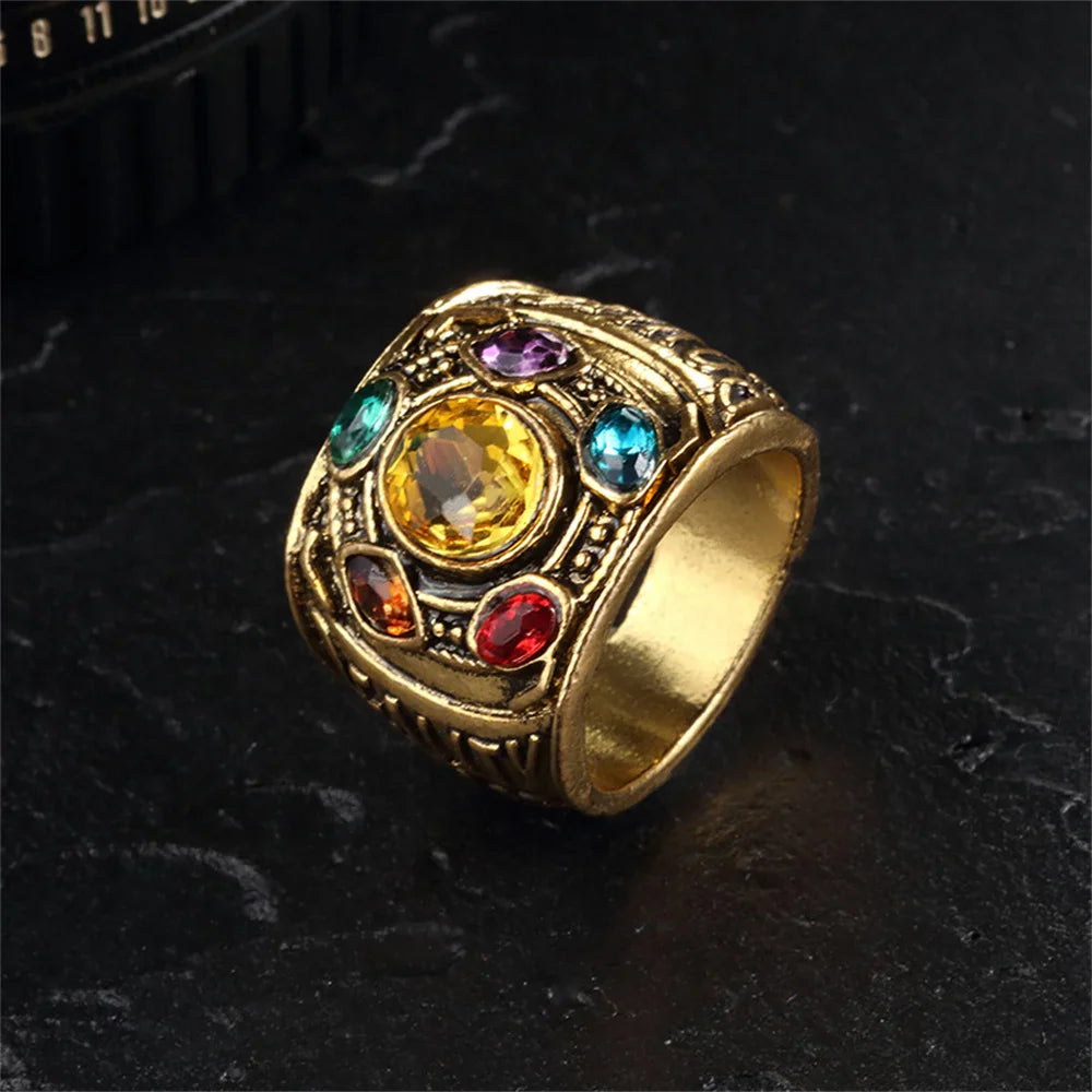 Gold tone metal ring featuring a central yellow stone surrounded by smaller colorful gems