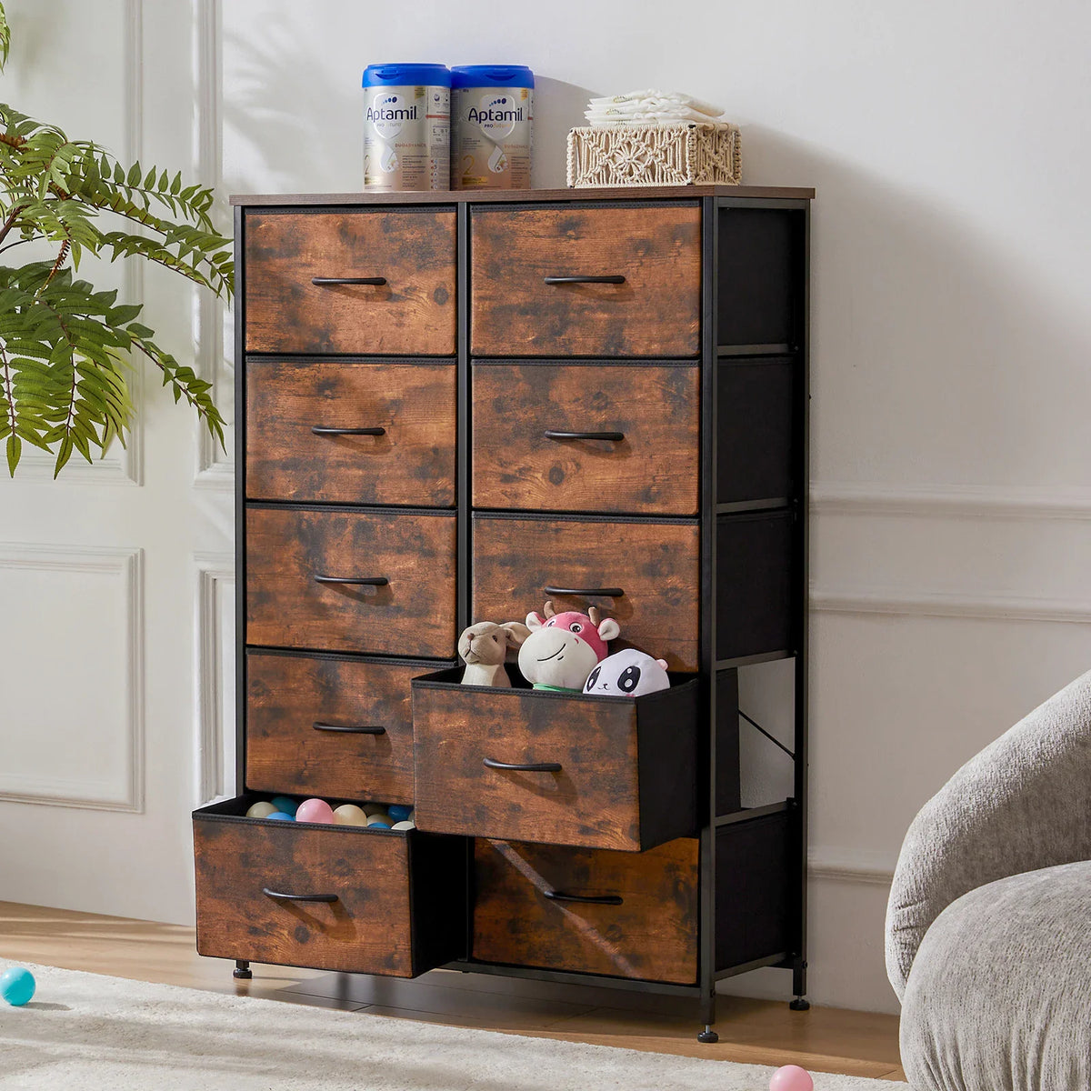 A 10-drawer rustic wood storage cabinet with black metal frame filled with children's toys and baby supplies.