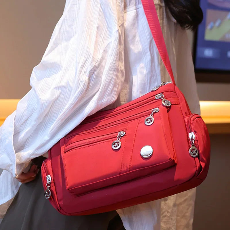 Red nylon crossbody bag worn by a person