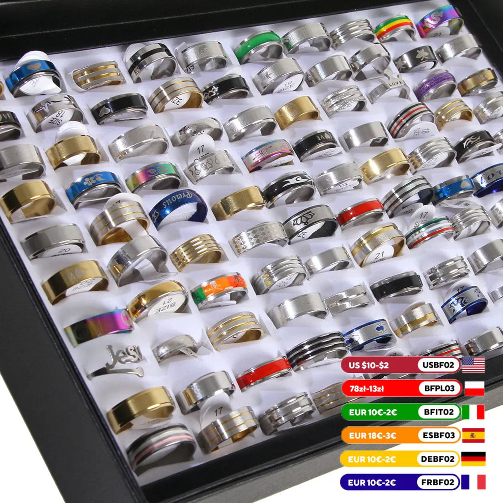 A large collection of mixed stainless steel rings for men and women displayed in a storage tray with size tags.