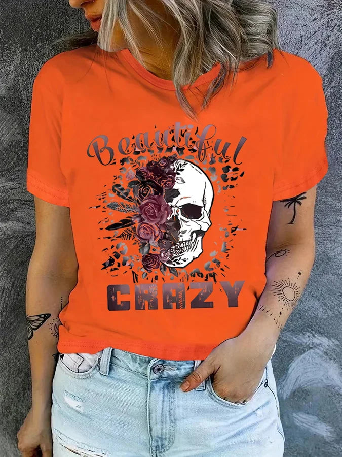 Orange short sleeve t-shirt with floral skull graphic and text on a woman