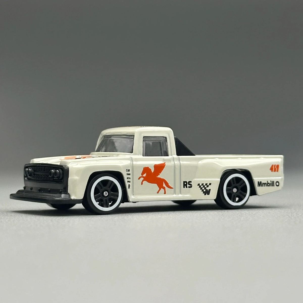 Side profile of a white diecast pickup truck toy with racing graphics