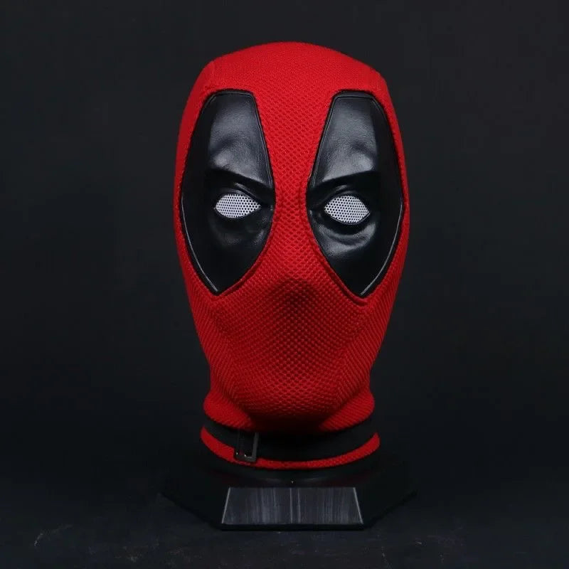 Red and black knitted superhero mask on a black display stand