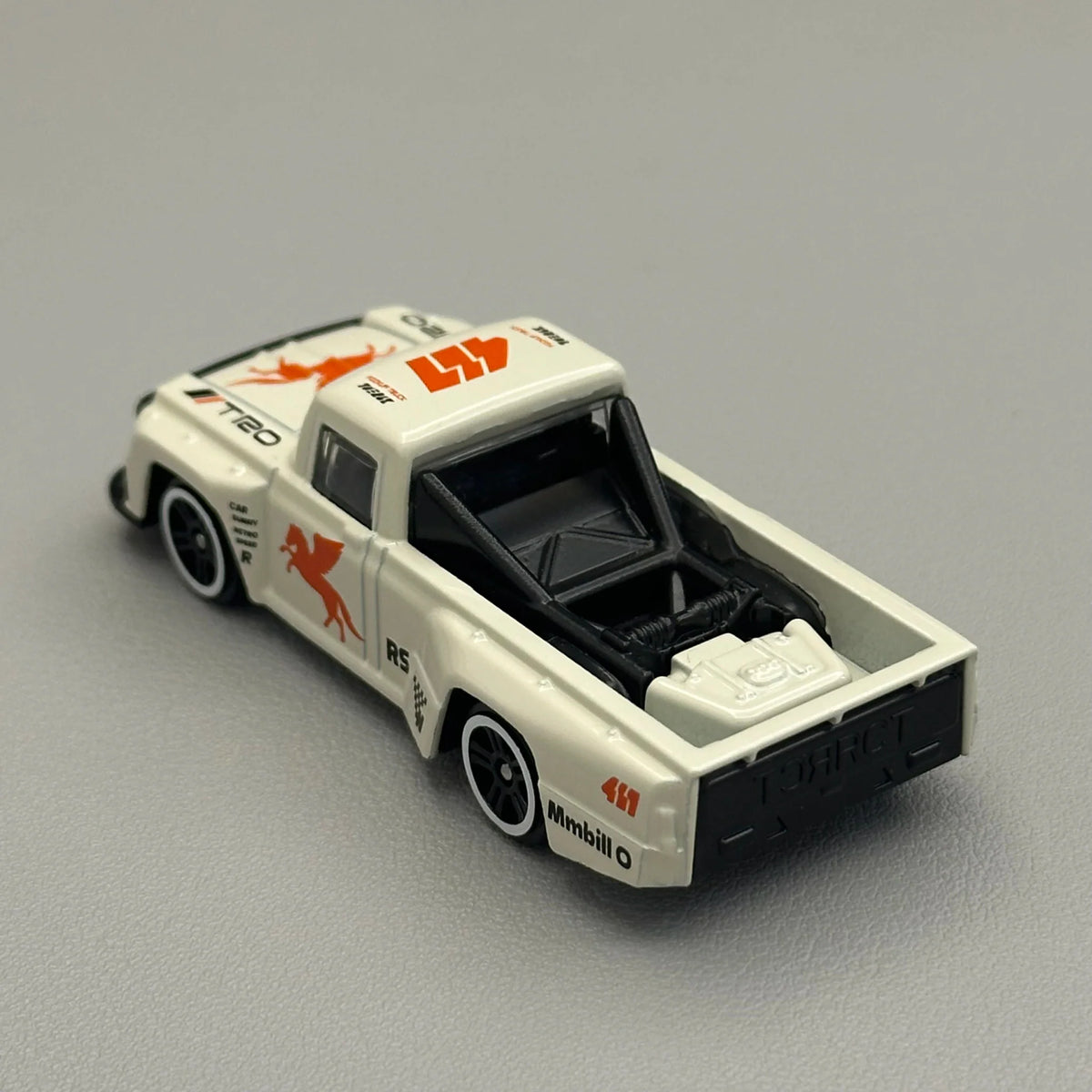 Rear angle view of a white diecast pickup truck toy with roll cage