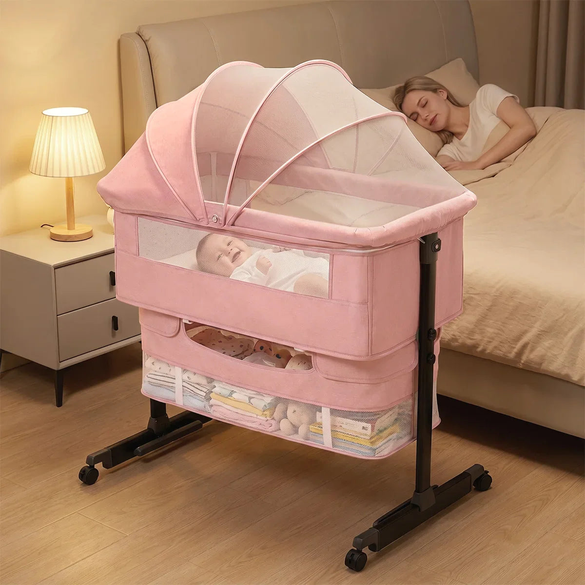 Mother sleeping in bed next to a baby in a pink bassinet at night
