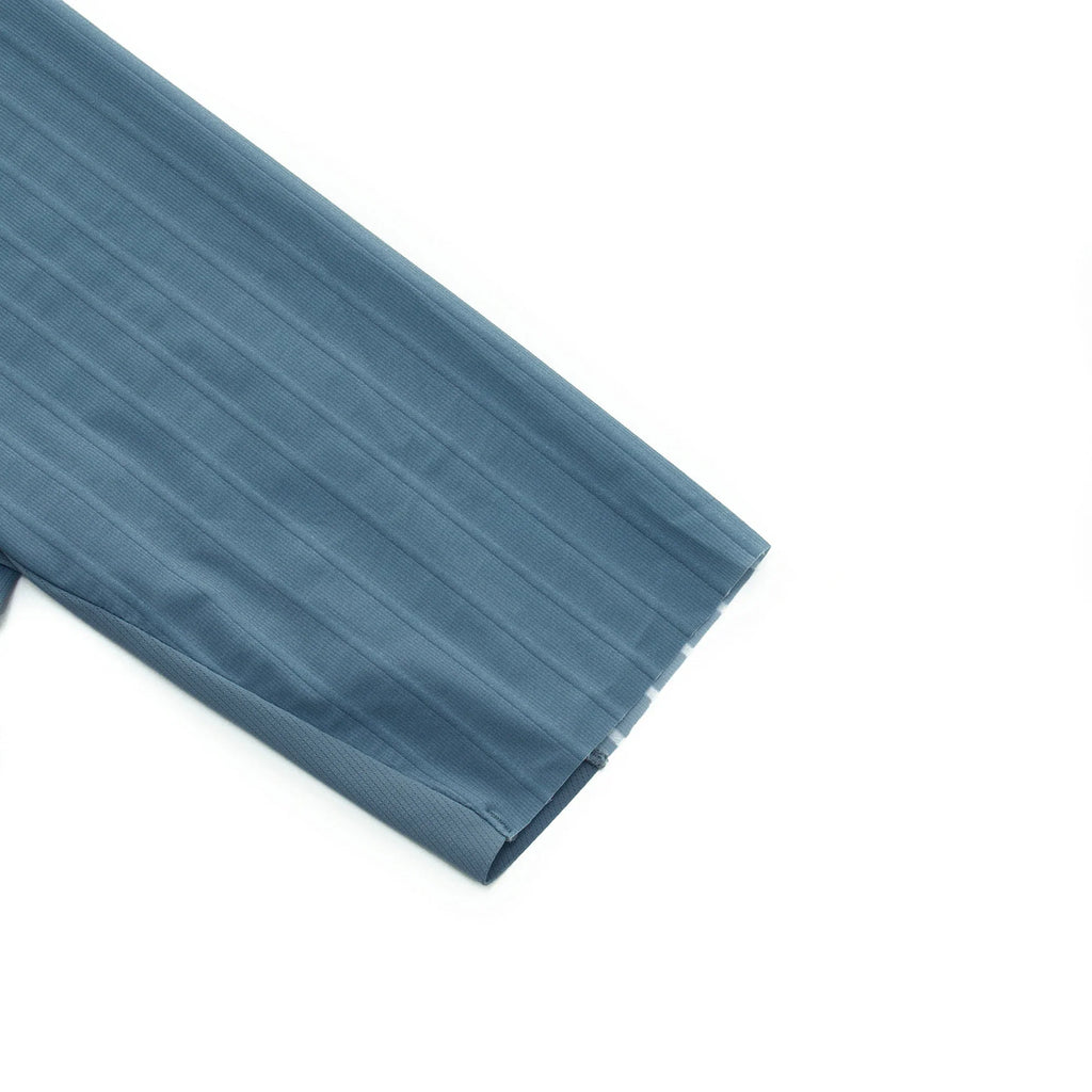 Close-up of the sleeve of a blue cycling jersey with textured vertical stripes