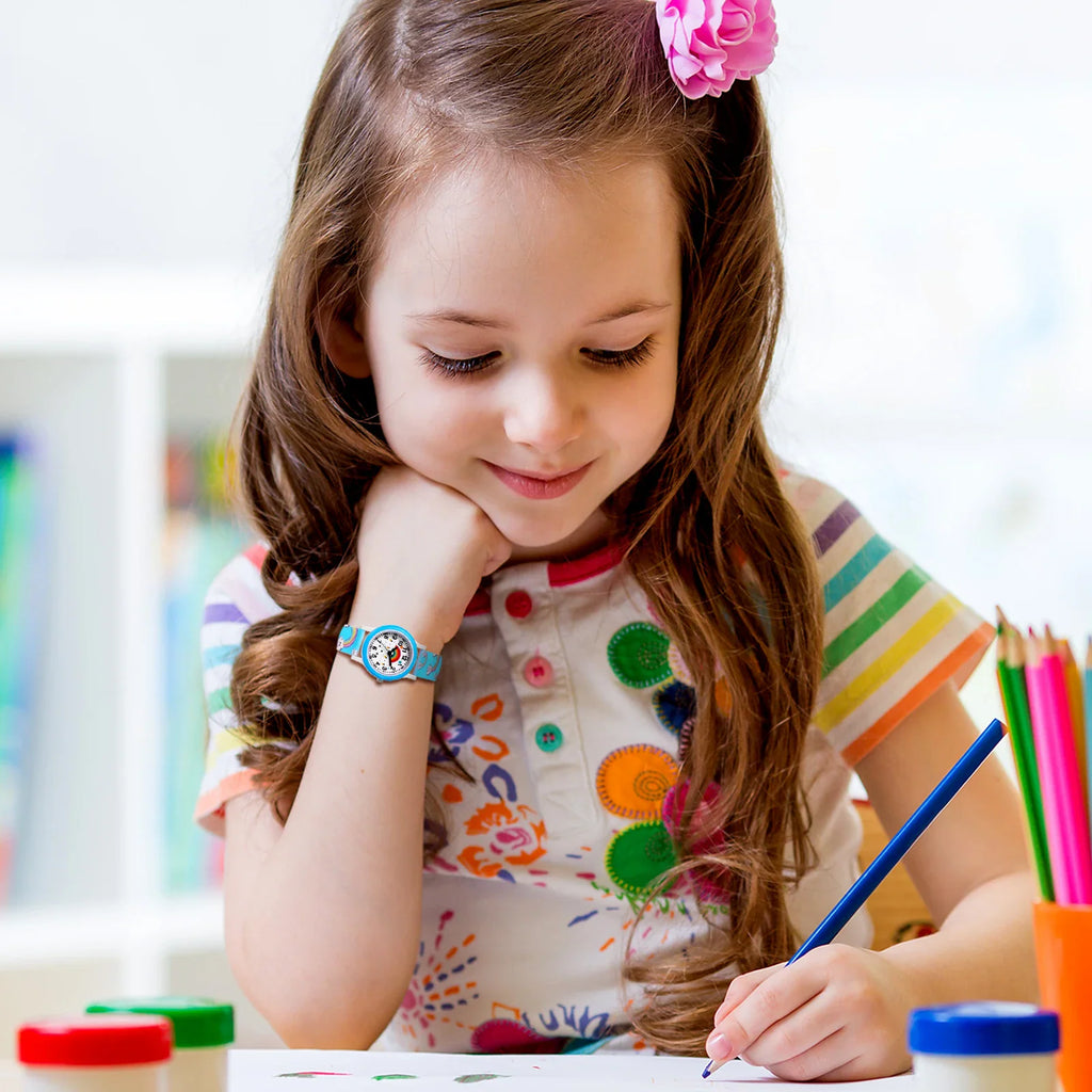 Young girl drawing with a blue rainbow-patterned watch on her wrist